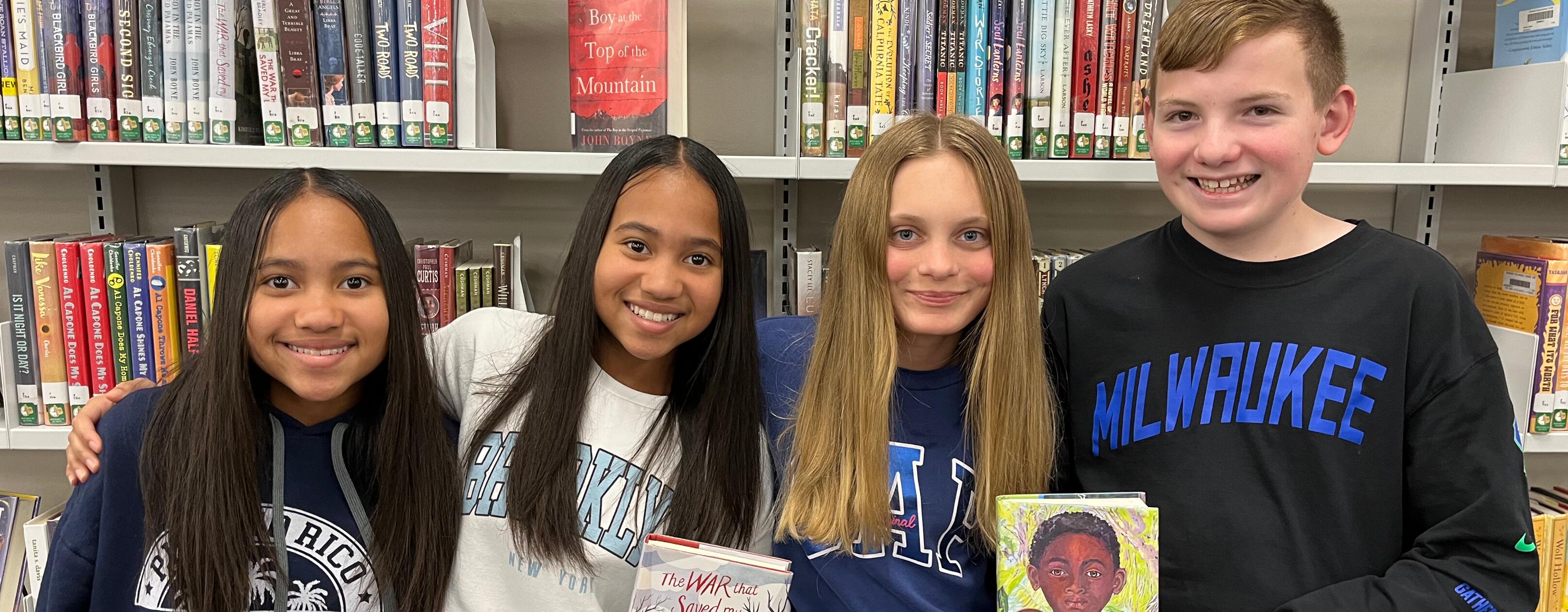 students holding books in the school library